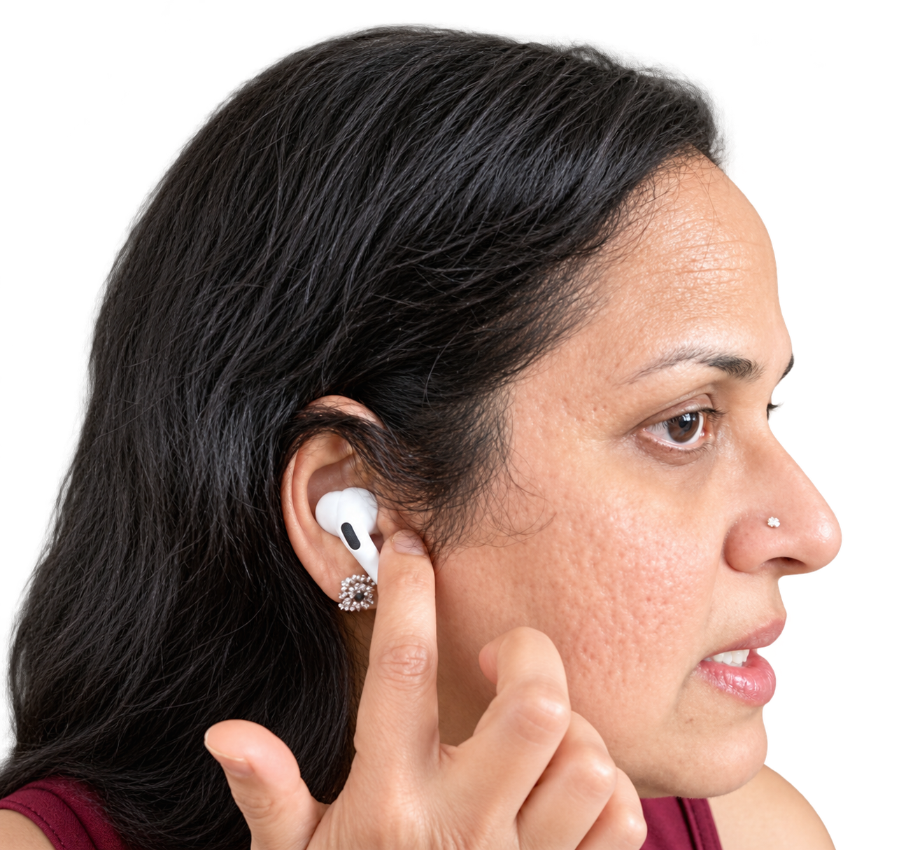 Side view of Dr. Malathi pointing to the small flap in front of her ear opening, where the thumb rests for humming breath.