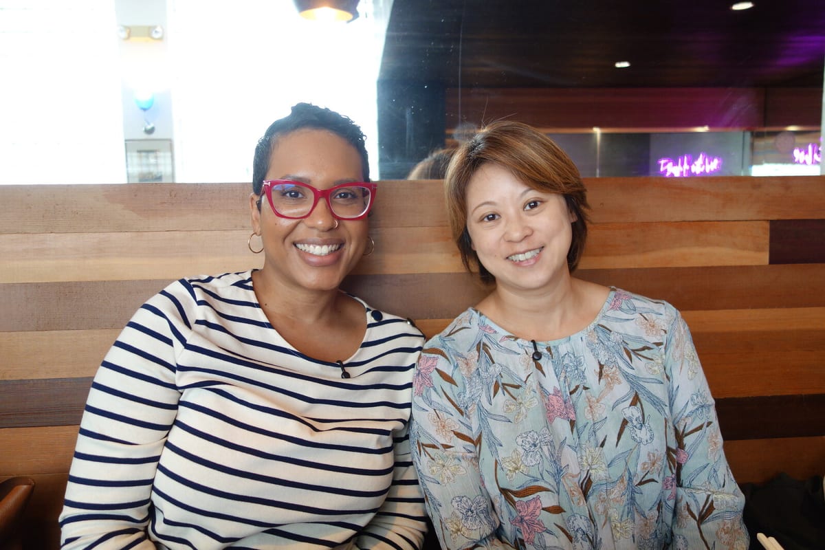 The two speakers smiling together after their Puzzle Exchange conversation about fertility treatment.