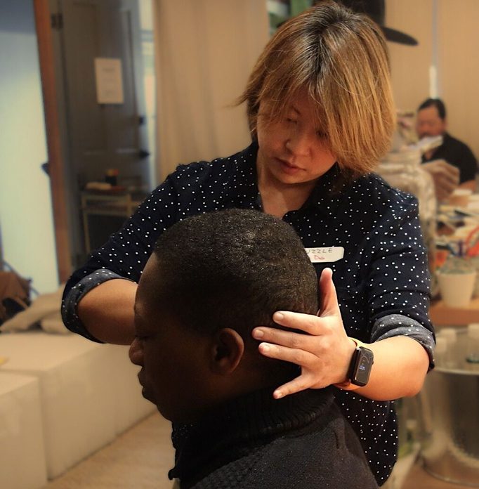 Dr Deb giving a seated patient a hands-on head and neck treatment