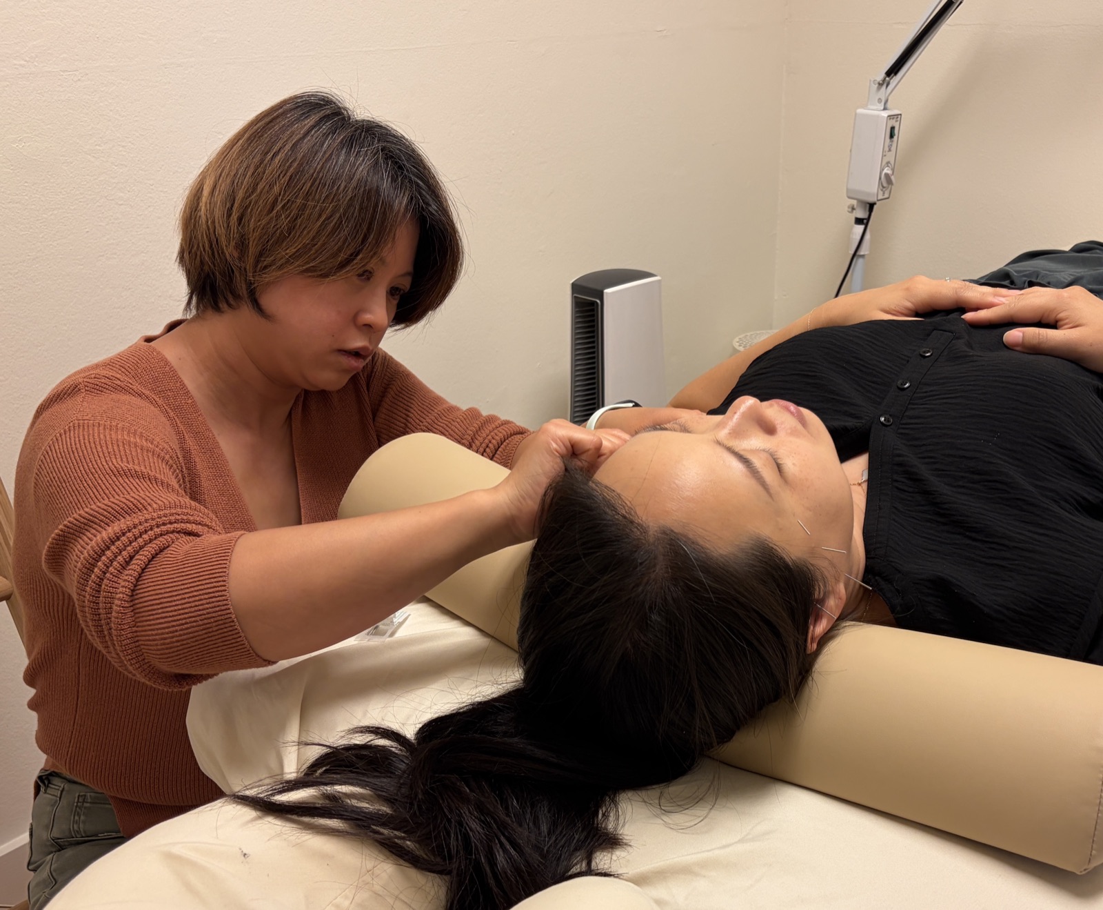 Dr Deb Ma treating a patient resting on a bolster